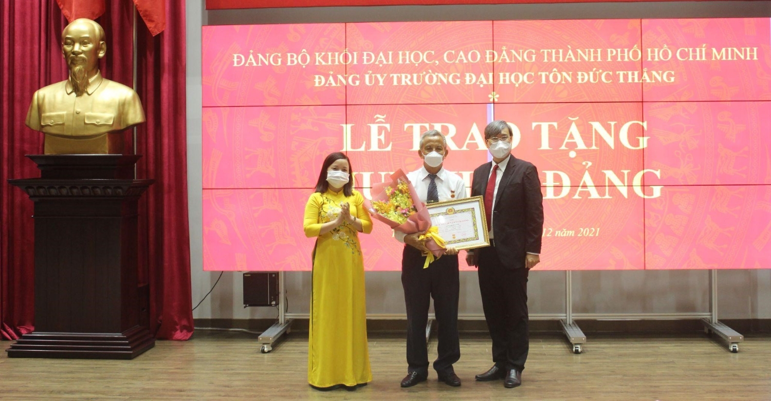 Đồng chí Đinh Thị Thảo Trang và đồng chí Vương Đức Hoàng Quân trao huy hiệu 40 năm tuổi Đảng cho đồng chí Đặng Ngọc Tùng